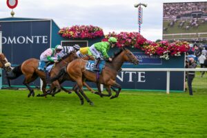 Jm Jungle wins the opening race of the Sky Bet Ebor Festival for John and Sean Quinn. A bay horse in green colours passes the winning post in front of three other horses in a line behind him.